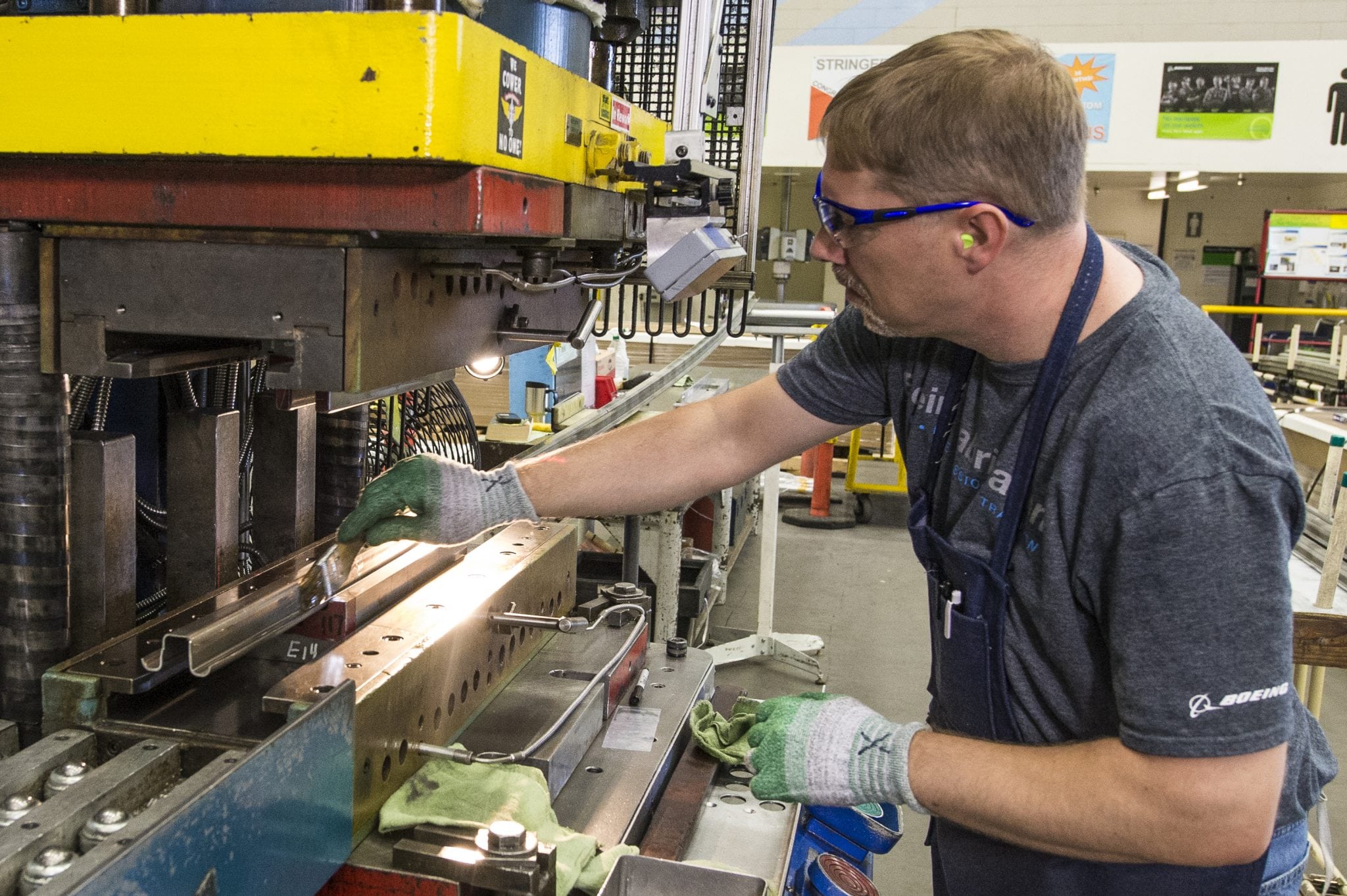Joggle Press operator Rich Harrison prepares the first 737 MAX fuselage stringer for the press