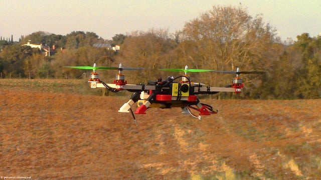 Quadcopter drone on cultivated field.