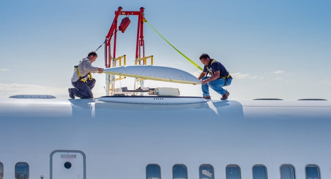 Technicians install GX Aviation antenna on aircraft