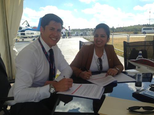 Adam Hahn, director of sales for Cirrus Aircraft; and Roohi Bali, sales manager for Cirrus India, signing contract.