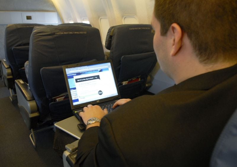 Man using laptop on airplane