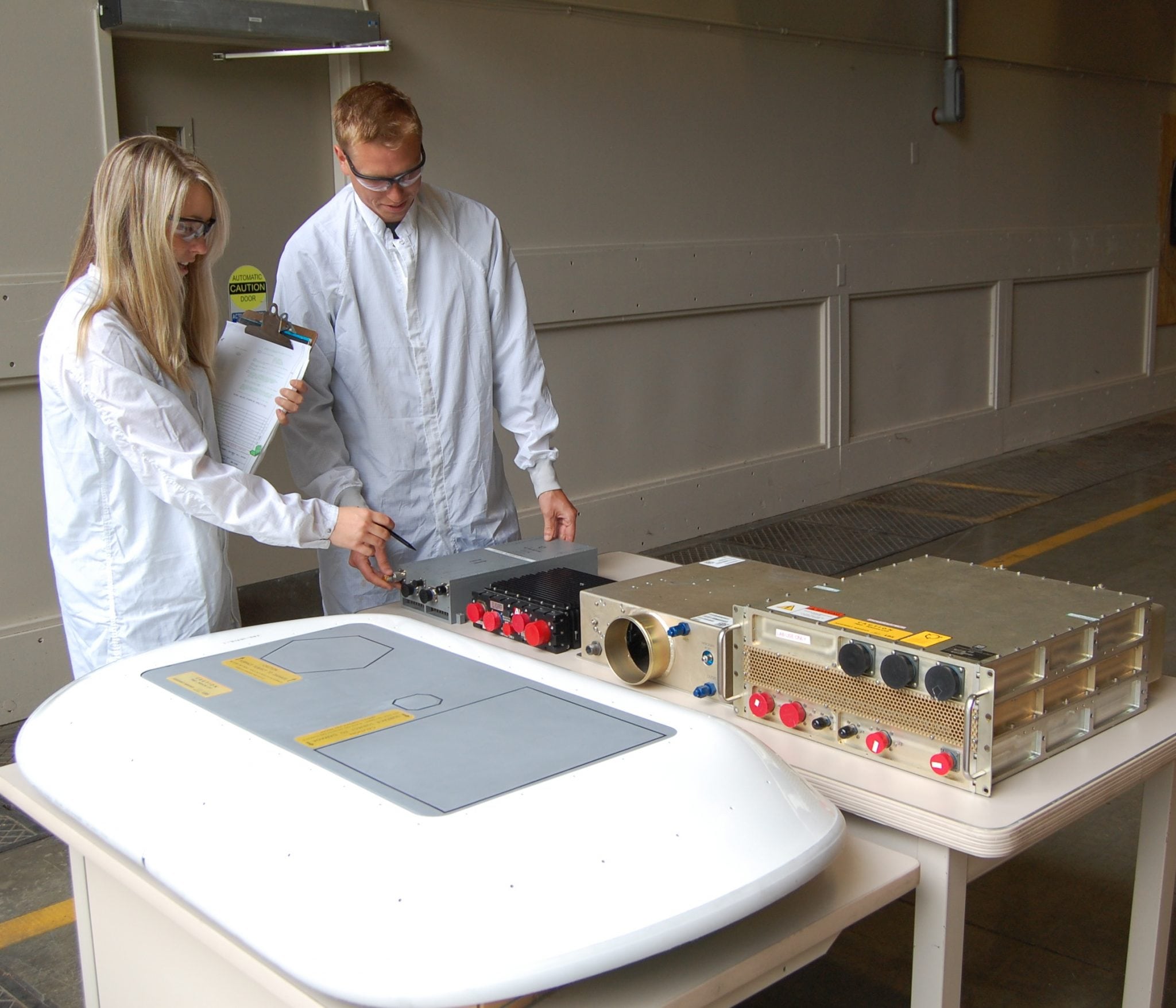 Boeing engineers Stephanie Mount and Chuck Renneberg examine the low-profile phased array antenna