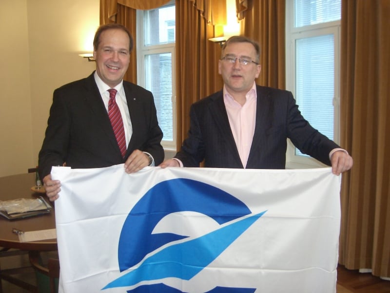 Frank Brenner, director general of Eurocontrol, and Juhan Parts, the Estonian minister for economic affairs and communications hold a flag bearing the Eurocontrol logo