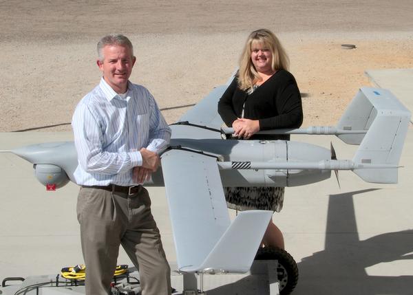 James Bell and Deidre Patin stand next to an unmanned aerial vehicle at Naval Air Warfare Center Weapons Division China Lake, Calif.