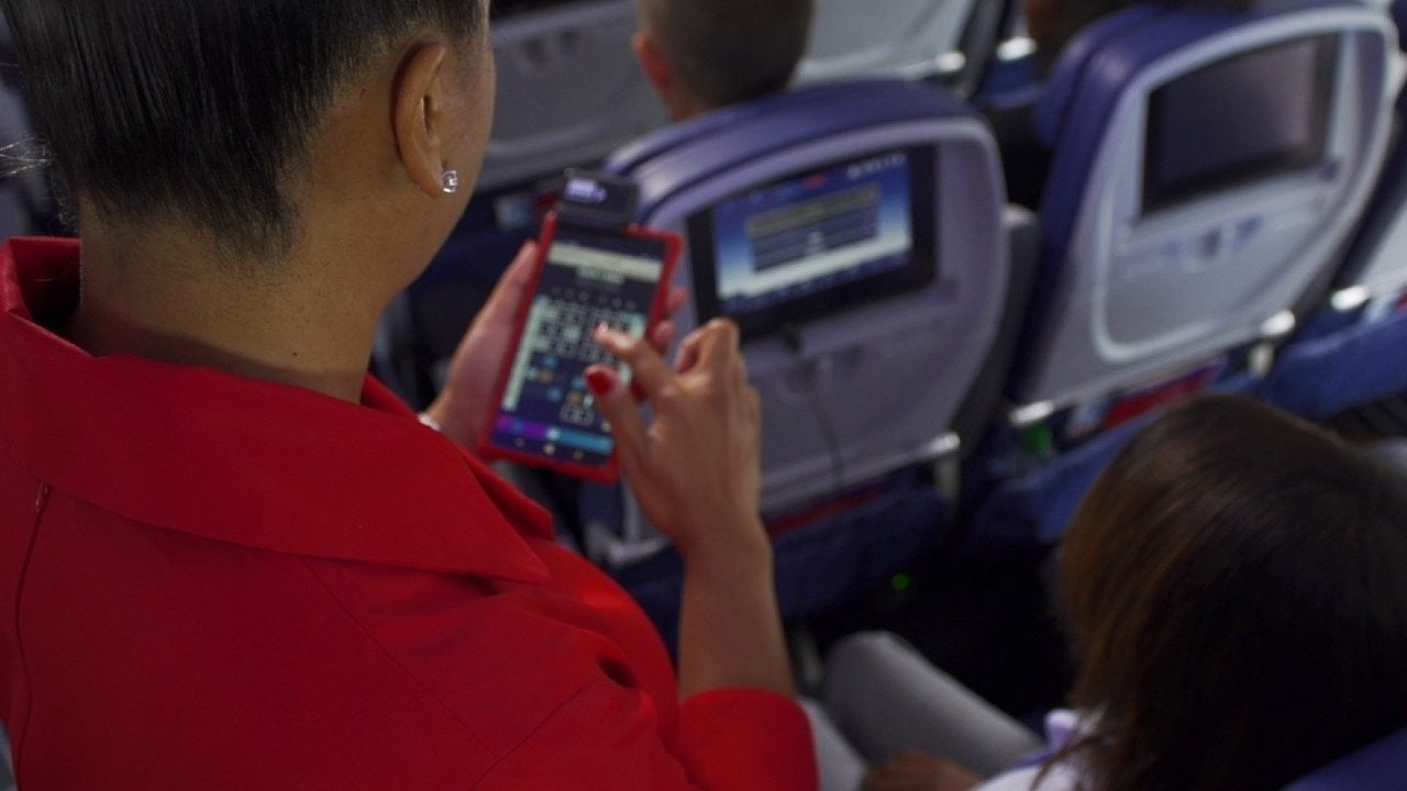 Delta Air Lines flight attendant using the new Guest Service Tool application