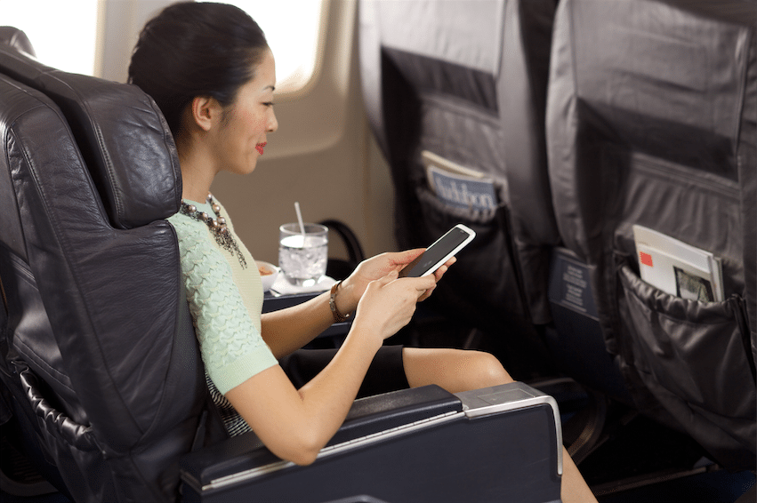 Airline passenger accesses in-flight Wi-Fi on her smartphone