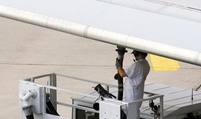 Airline workers re-fueling jet plane