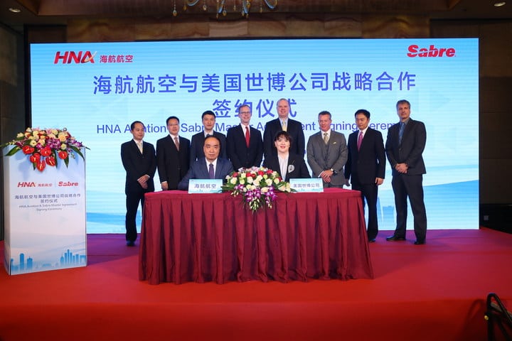 Dasha Kuksenko, Vice President and Regional General Manager APAC, Sabre signs the master agreement with He Haiyan, Information Technology Director of HNA Tourism Aviation Investment Holding Group. Behind from left to right are Zhang Wei, Wu Zhidian and Xie Haoming HNA; Scott Shaw and Steve Winkates from US Embassy; Greg Gilchrist, Peter Wu and Henning Bruns from Sabre. Photo: HNA