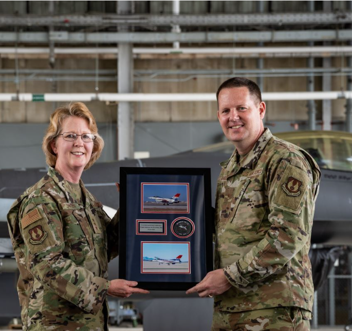 U.S. Air Force Brig. Gen. Jason Voorheis (right), Air Force Life Cycle Management Center program executive officer for fighters and advanced aircraft, presents Lt. Gen Donna Shipton (left), AFLCMC commander, with a token of appreciation during an F-16 Golden Anniversary ceremony at Wright-Patterson AFB, Ohio on June 25 (U.S. Air Force Photo)