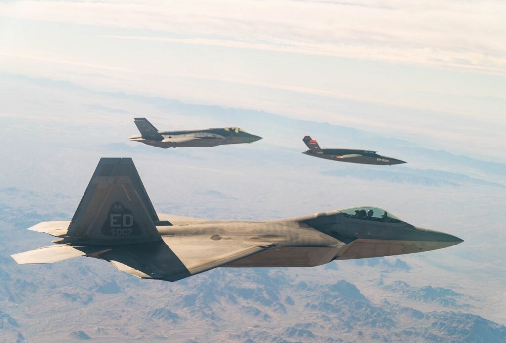 A U.S. Air Force F-22 Raptor and F-35A Lightning II fly in formation with the XQ-58A Valkyrie low-cost unmanned aerial vehicle over the U.S. Army Yuma Proving Ground testing range, Ariz., during a series of tests Dec. 9, 2020. (U.S. Air Force Photo)